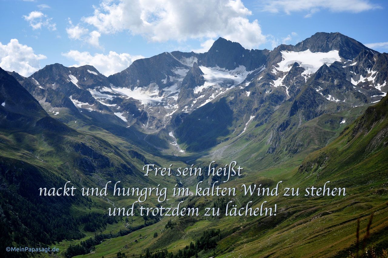 Bergpanorama mit dem Spruch: Frei sein heißt nackt und hungrig im kalten Wind zu stehen und trotzdem zu lächeln!